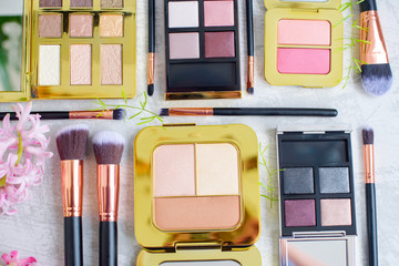 premium makeup brushes, palette eye shadow makeup and blush pads on a marble background, creative...