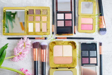 premium makeup brushes, palette eye shadow makeup and blush pads on a marble background, creative cosmetics flat lay