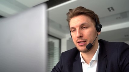 Businessman in the office on the phone with headset - Powered by Adobe