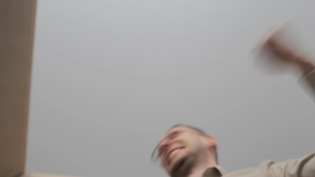 Man opens a cardboard box and reacts very emotionally to the contents inside. Glad, happy and surprised to receive such a gift, a parcel. Inside view of the box