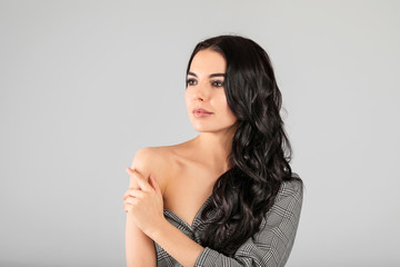 Naklejka premium Young woman with beautiful healthy hair on grey background