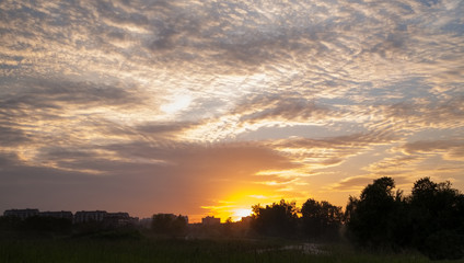 Amazing cloudy pattern with sunset over small town