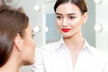 Makeup artist looks on client ready to work with client.