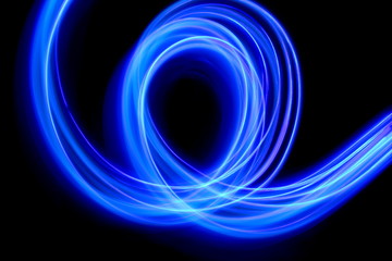 Long exposure photograph of neon purple streaks of light in an abstract swirl, parallel lines pattern against a black background. Light painting photography.