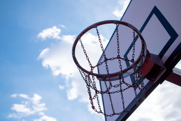 metal mesh of basketball basket against cloudy sky background