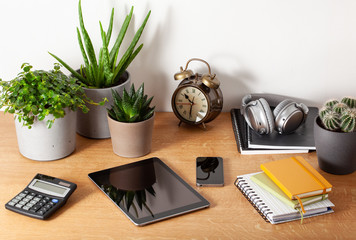 home office desk with tablet computer smartphone notebook houseplants, working space at home