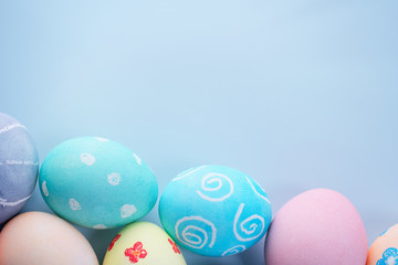 Fototapeta na wymiar Colorful Easter hunting eggs dyed by colored water with beautiful pattern on pastel blue background, design concept of holiday, top view, copy space.