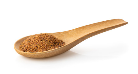 Nutmeg powder in wood spoon on white background