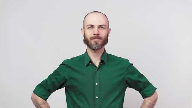 Portrait of calm bearded man looking at camera and smiling isolated over white background. Concept of emotions.