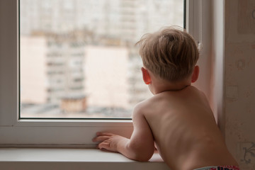 Little boy looking out the window. close-up	