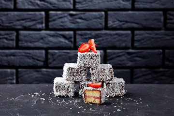 Lamingtons mini cakes with strawberries on a table