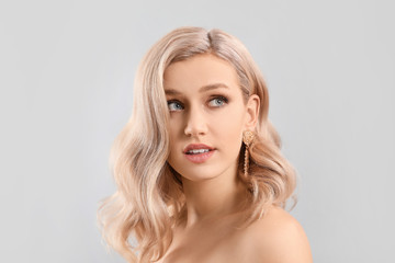 Young blonde with beautiful hair on light background