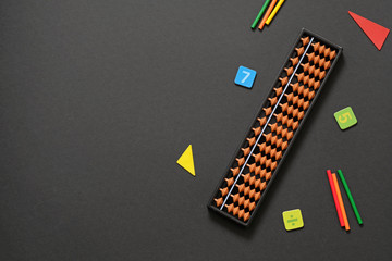 Abacus with numbers on black background - mental mathematics, arithmetic, math concept.