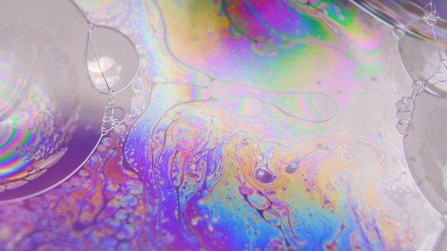 Purple liquid flow creating bubbles in different colors. Psychedelic concept
