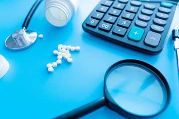 pills and medicines under a magnifying glass next to a medical stethoscope. The concept of health...