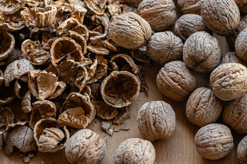 whole and broken walnuts on a wooden background