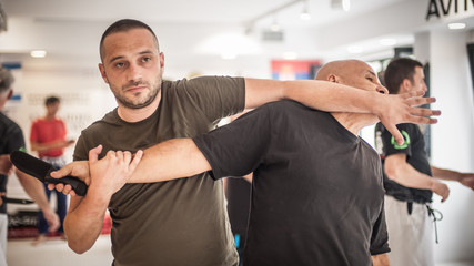 Two students train knife disarm techniques on martial arts seminar