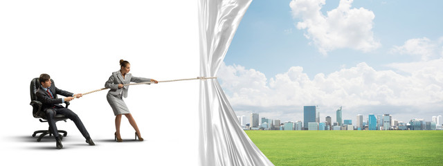 Young businesspeople working in collaboration and pulling white advertisement banner