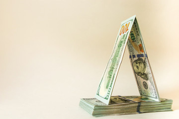 American 100 dollar bills are folded in the form of a house of cards. Savings, planning, forecasts.