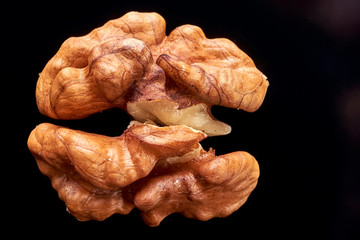 walnut lies on a black surface. closeup. peeled nut