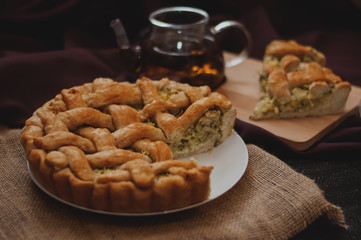 a large cabbage or Apple pie on a dark background and linen sacking. Rustic style. natural material. Wood, glass, fabric