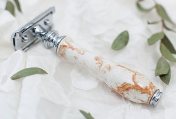 safety razor in the style of zero waste. Metal machine with ceramic handle on a white background...