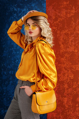 Fashion portrait of elegant woman wearing orange color sunglasses, beret, blouse, with leather shoulder bag
