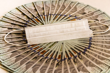 A fan of hundred-dollar bills on a light background. Economic problem and the concept of resolution of the outbreak of coronavirus.Virus. Pandemic. Bankruptcy. Finance, investment, and Economics.