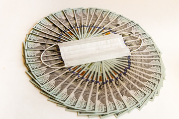 A fan of hundred-dollar bills on a light background. Economic problem and the concept of resolution of the outbreak of coronavirus.Virus. Pandemic. Bankruptcy. Finance, investment, and Economics.