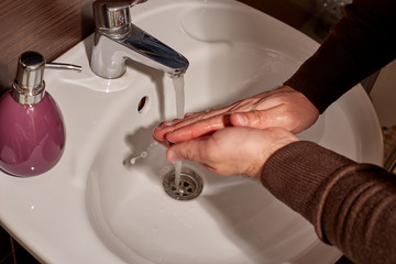 Wash hands with soap under the tap with water. Hand washing with soap and water to prevent...