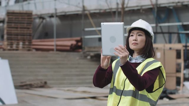 Construction supervisor taking picture with digital tablet of project development