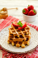 Fresh strawberries and Belgian waffles on wooden background