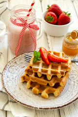 Fresh strawberries and Belgian waffles on wooden background