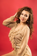 Portrait of beautiful young woman with perfect makeup. Fashion beauty portrait on red background.