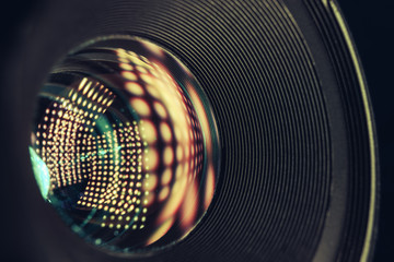 Beautiful camera lens with yellow light bulb of glass on a black background...