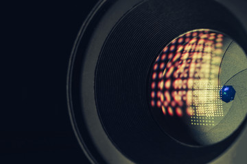 Close up beautiful camera aperture lens with multi colored light glass reflection. Macro view.