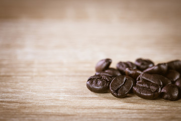 Close up brown roasted coffee beans on wooden background,  Retro vintage style