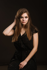 Fashion studio portrait of young beautiful woman on black background