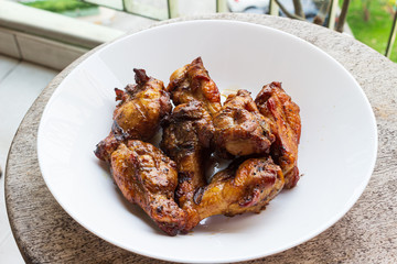 Delicious portion of grilled chicken legs served in a white plate