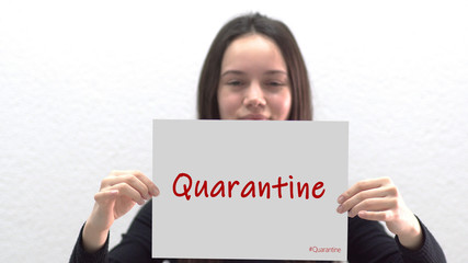 Female teen  holding a sign saying quarantine, shome quarantine selective focus