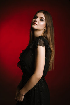 Fashion studio portrait of young beautiful woman on black and red background