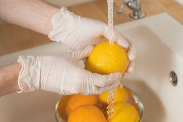 A young man sterilizes fruits and vegetables during an epidemic. Hands in disposable gloves...