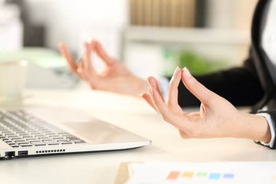 Executive hands relieving stress doing yoga at office