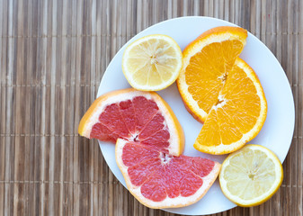 fruits oranges, grapefruits, lemons on a white plate-vitamins for immunity, epidemic, COVID-19