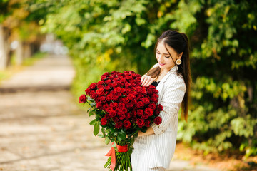 Valentines day. Woman holding bouquet of red roses. Beautiful girl received romantic present.