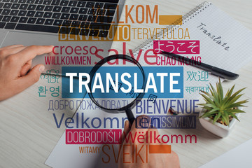 cropped view of translator working with hieroglyphics, laptop and magnifying glass, welcome...
