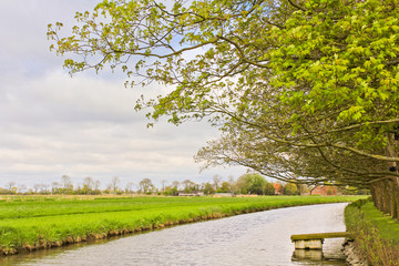 Landscape in northern Germany with a river and green meadows.