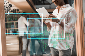 cropped view of african american businesswoman using digital tablet near multicultural colleagues, data illustration