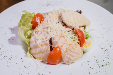 Delicious fresh caesar salad on a large white plate.