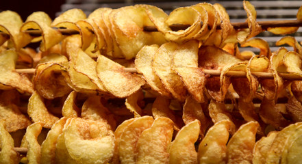 Nahaufnahme von gedrehten Kartoffelchips auf einem Holzspieß